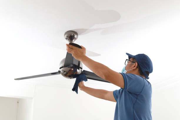istock Asian man wearing a protective mask cleaning ceiling fan at home 1297417611