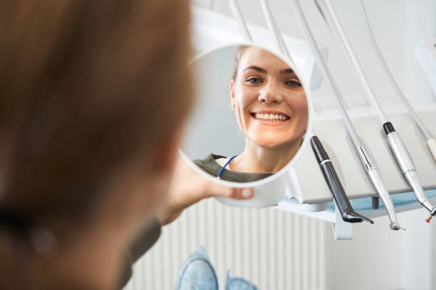 istock Attractive caucasian lady checking her beautiful smile in mirror 1297421082
