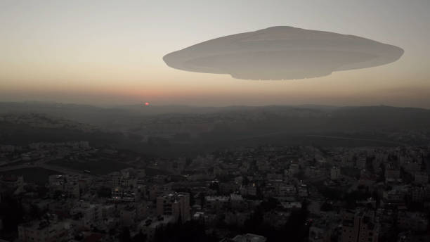 istock Alien Spaceship ufo hovering over city at sunset - aerial view 1297422508