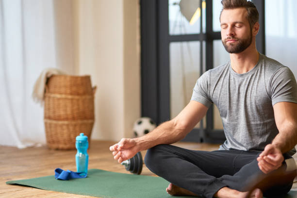 istock Handsome young man doing meditation exercise at home 1297423595