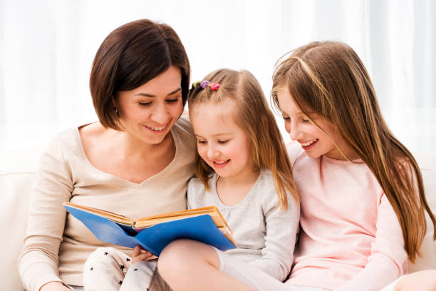 istock Mom and daughters reaading children's book 1297425510