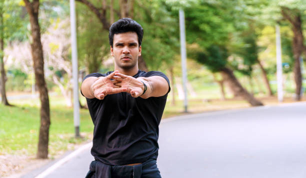 istock Athlete young man stretching arm shoulder before workout in the park. Trainer male warming up preparation body before running at outdoor. Healthy lifestyle concept. 1297426000