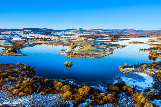 The early morning aerial view from a drone flown near calm water on a frosty morning in south west Scotland The aerial view from a drone of a stretch of water in rural Dumfries and Galloway south west Scotland after a period of cold weather has left frost and ice on the ground Galloway Hills stock pictures, royalty-free photos & images