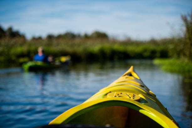 la coque d’un canoë sur le fond flou de la rivière - canoe kayak, jaune photos et images de collection