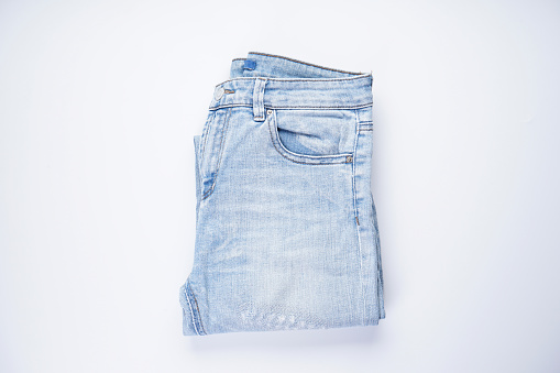 Blue jeans folded on a white background flat lay.