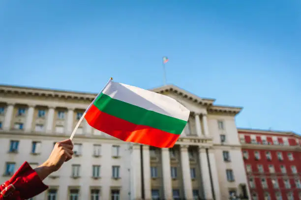 Woman waving the Bulgarian flag in the center of Sofia, Bulgaria. Protest / Patriotism / Human rights concept. Nationalism / Patriotism concept.