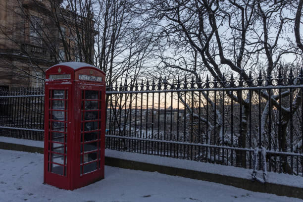 Traditional red British telephone box covered with snow stock photo