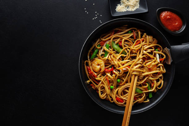 istock Asian noodles with vegetables and sesame served on pan. 1297431439