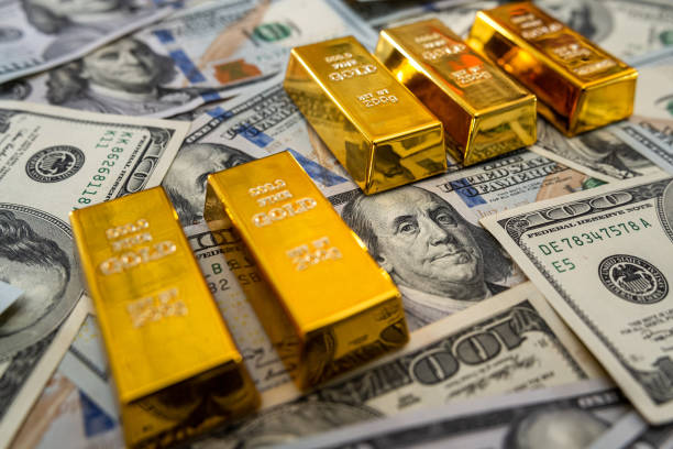 istock gold bars on American dollar bills 1297432293