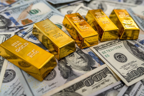istock gold bars on 100 new US dollar banknotes 1297432384