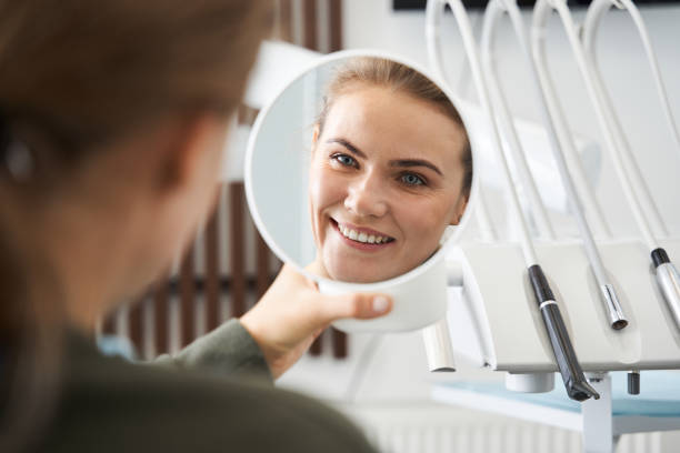 istock Attractive caucasian lady checking her beautiful smile in mirror 1297434059