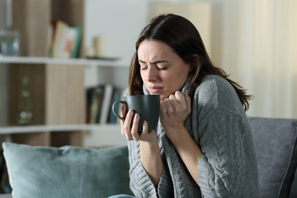 mujer enojada enfriarse sosteniendo taza de café en casa - garment emotional stress equipment household equipment fotografías e imágenes de stock