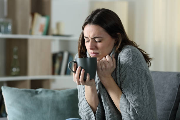 angry woman getting cold holding coffee mug at home - garment emotional stress equipment household equipment imagens e fotografias de stock