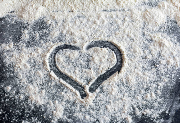 istock The heart is drawn on flour scattered on a dark table. 1297434714