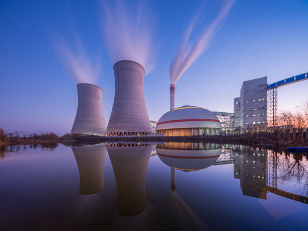 At dusk, the thermal power plants Nuclear power plant after sunset. Dusk landscape with big chimneys. nuclear energy stock pictures, royalty-free photos & images