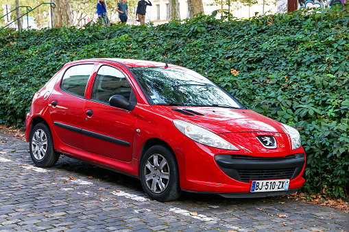 Versailles, France - September 15, 2019: Red compact car Peugeot 206+ in the city street.