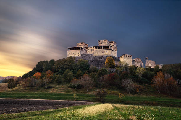 Torrechiara Italian castle during a unique sunset, Parma, Italy Scenic long exposure view of famous medieval italian castle during a unique sunset, Torrechiara, Parma, Italy parma italy stock pictures, royalty-free photos & images