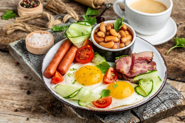 istock Traditional English breakfast with fried eggs, bacon, beans, coffee and sausage, Restaurant menu, dieting, cookbook recipe 1297437461