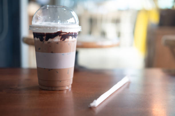 istock Ice cold coffee mocha in plastic glass on wood table at coffee shop. Refreshing drink 1297438021