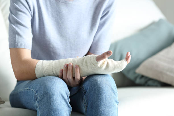 Disabled woman grabbing her painful bandaged arm Disabled woman grabbing her painful bandaged arm bone fracture stock pictures, royalty-free photos & images