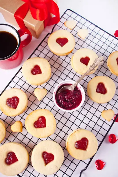 Heart shaped traditional linzer cookies with strawberry jam on the baking rack. Valentine s day concept. Top view.