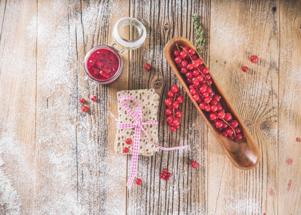 Red berries  with toast on wooden plate at retro concept.