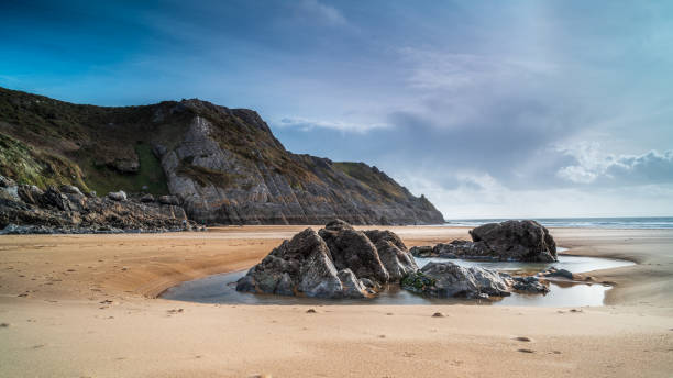Tidal rock pools on a beach in south Wales. The day is sunny Tidal rock pools on a beach in south Wales. The day is sunny gower peninsular stock pictures, royalty-free photos & images