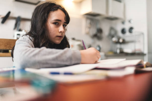 istock schoolgirl looking at digital tablet at kitchen table for homeschooling 1297446652