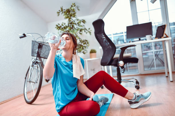 istock Female Drinking Water After Working Out At Home 1297448899