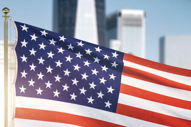 istock USA flag on blurry skyscrapers background, close up 1297449508