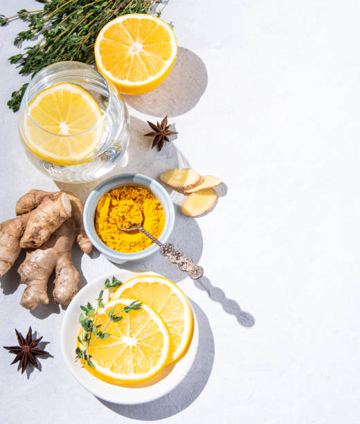 istock Immune boosting remedy. Flat lay  with ingredients from turmeric, thyme, lemon, star anise and glass water with lemon on white background with hard shadows 1297449584