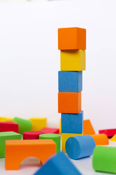 istock A child builds a pyramid of cubes on a white background. 1297449927