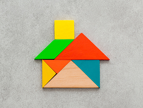 House shape made with colorful wooden tangram puzzle pieces