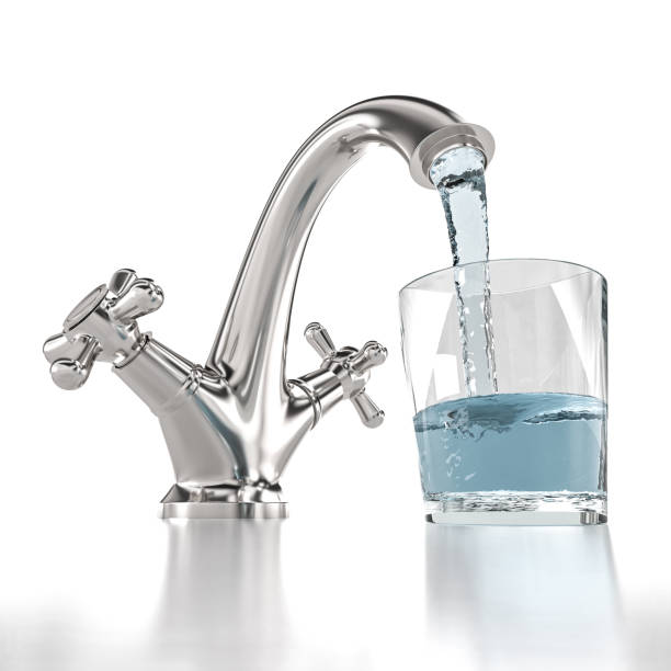 istock tap from which water flows and fills a glass. 1297456209
