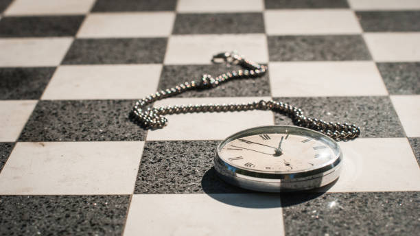 An old pocket watch on a chessboard background.
