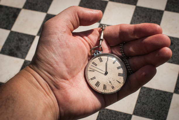 istock A man holding an old pocket watch in his hand. 1297456312