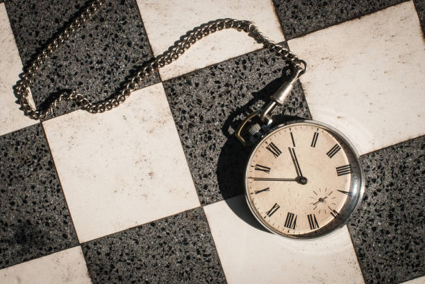 istock An old pocket watch on a chessboard background. 1297456313