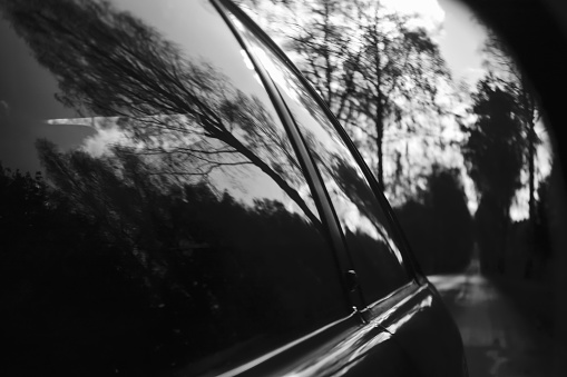 reflection of the car from the side mirror  in black and white
