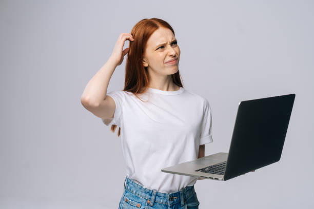 istock Thoughtful young woman student using laptop computer and touching head to thinking new ideas. 1297460571