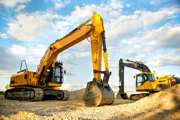 Excavator digs gravel stock photo horizontal,photography,slate-rock,vibrant color,clay,ditch,growth,loading,machine valve,mine,relocation,multi colored,lens  flare,cloud-sky,blue,coal mine,large,metal industry,sunrise-dawn, mechanical digger stock pictures, royalty-free photos & images