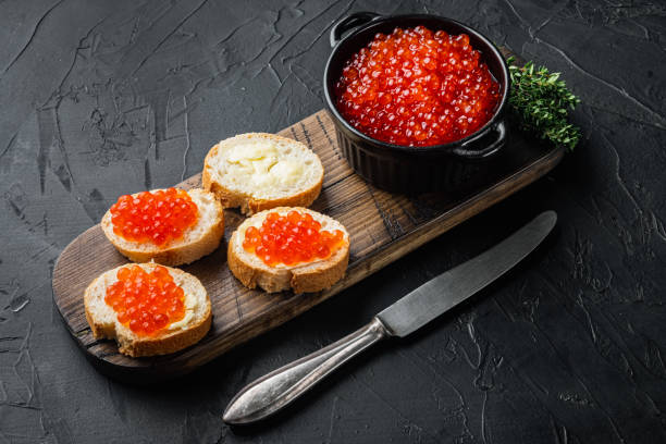 istock Bruschettes with butter red caviar, on black background 1297461945