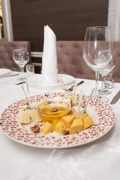 istock Cheese plate with honey and nuts on holiday dinner table, copy space. Wedding or birthday reception 1297462000