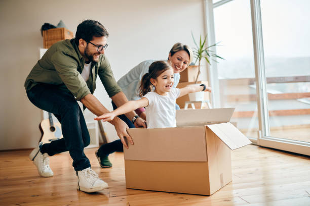 istock Happy daughter having fun with her parents while relocating in new apartment. 1297462024