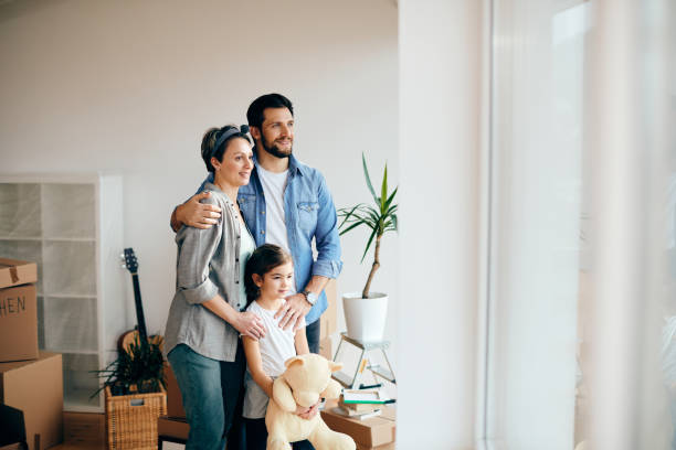 istock Happy family looking through the window while moving into a new home. 1297462069