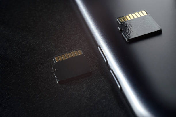 istock Flash memory storage concept: Micro SD card on the background of a smartphone. A memory card is used to store digital information in portable electronic devices such as mobile phones, tablets, etc. 1297462101