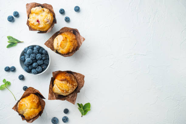 Blueberry muffins with fresh berries, on white background, top view flat lay with copy space for text