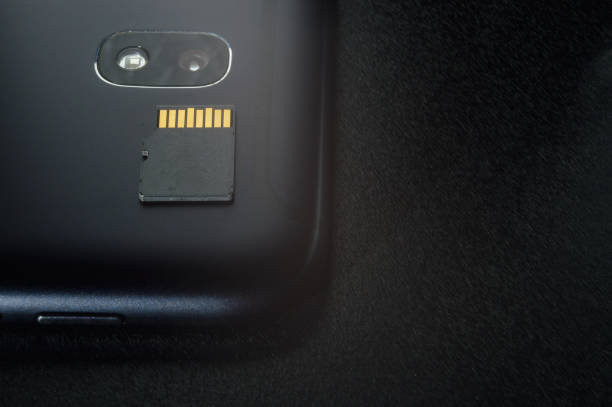istock Flash memory storage concept: Micro SD card on the background of a smartphone. A memory card is used to store digital information in portable electronic devices such as mobile phones, tablets, etc. 1297462557