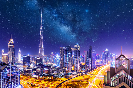 Amazing skyline cityscape with illuminated skyscrapers. Downtown of Dubai at night with stars and milky way, United Arab Emirates