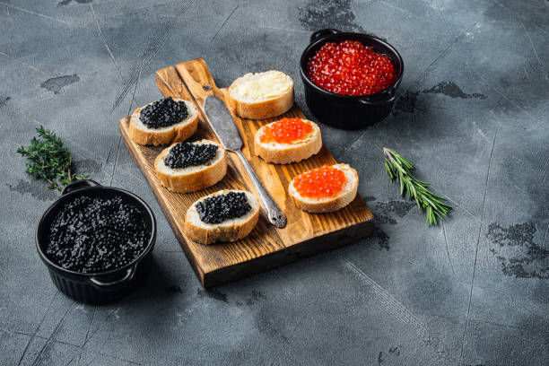 istock Bruschettes with butter red and black caviar, on gray background 1297463843