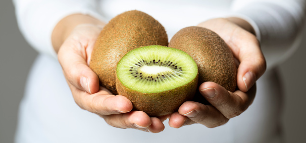 Delicious ripe lots of kiwi fruit and kiwi in a cut on a light concrete background. close-up . space for text